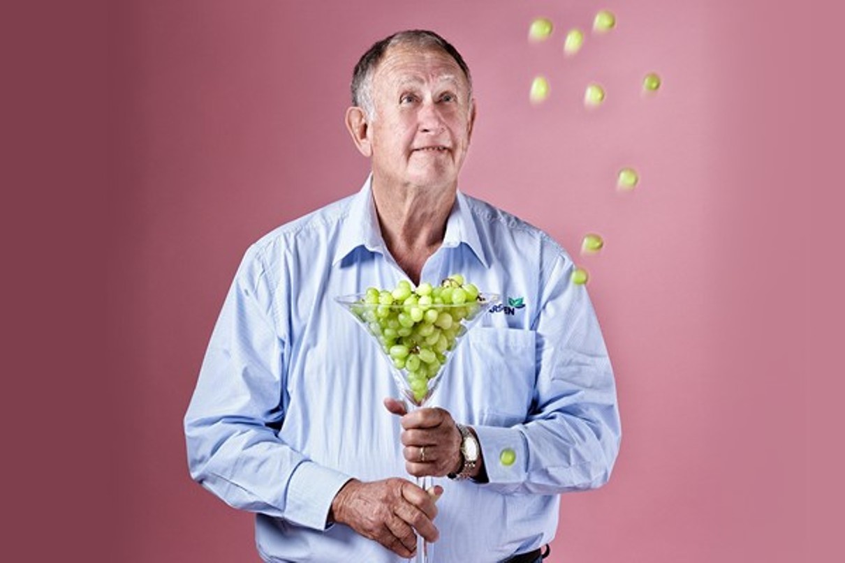 A picture of a man, Piet Karsten, holding a large glass of grapes.