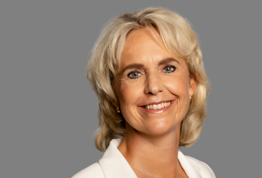 The portrait photo of a blonde woman, Janine Luten, in a white blazer.