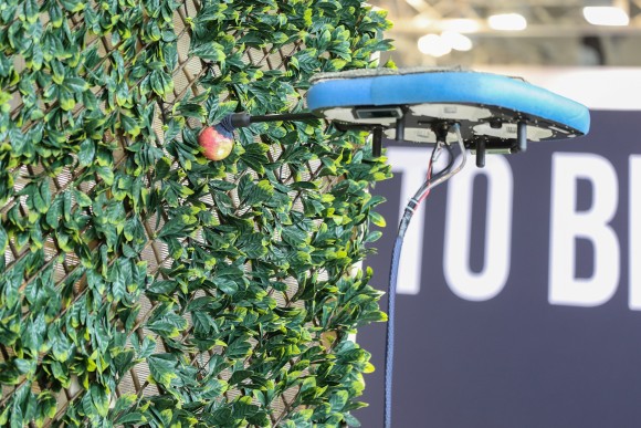 A drone picks an apple and symbolises progress in Smart Agriculture, Farming Forward and Vertical Farming. 