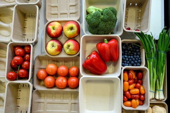 From above, we see a selection of cardboard containers in various shapes and sizes, filled with different types of fruit and vegetables.